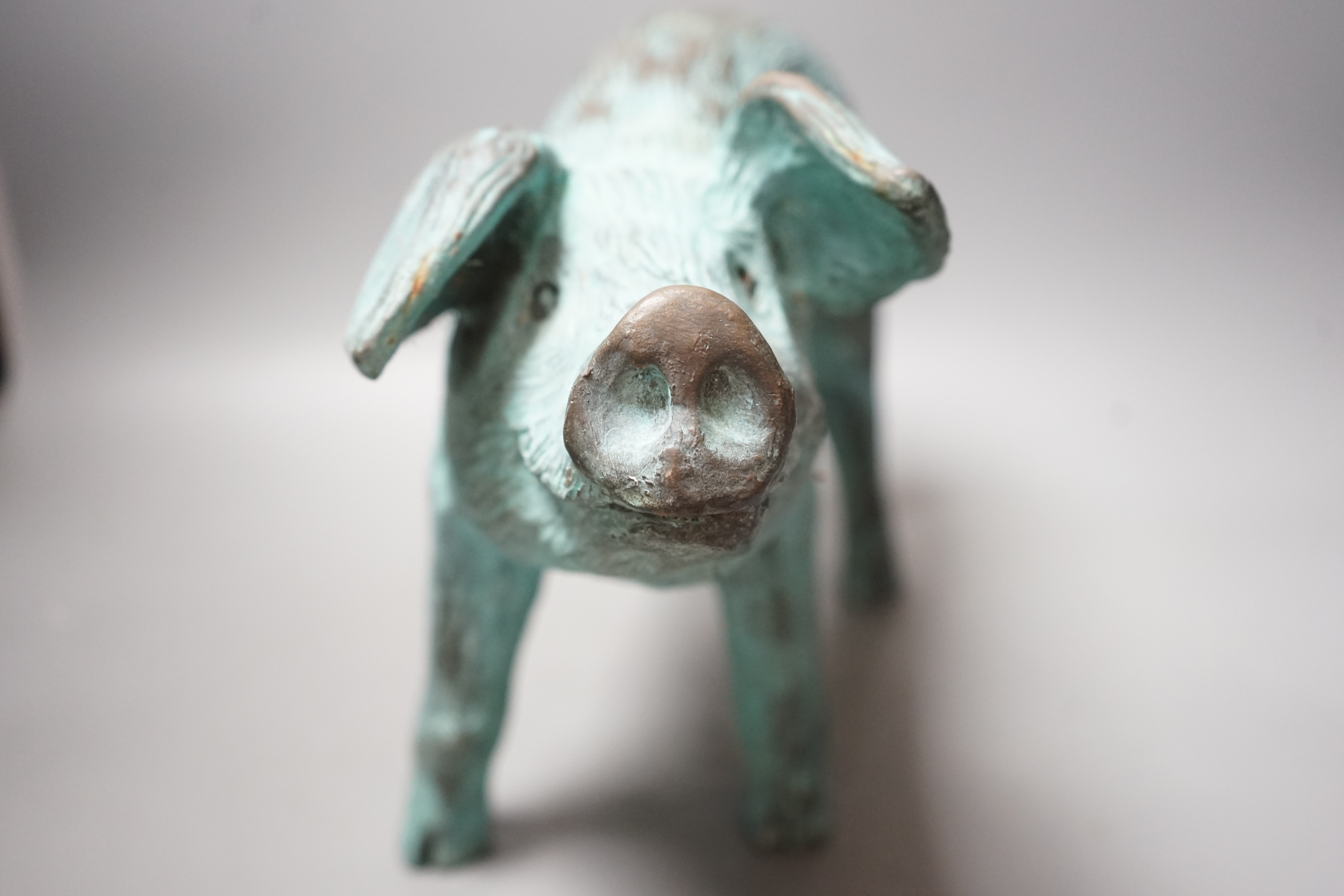 A cold cast resin bronze pig initialled 'JP', 40cm wide